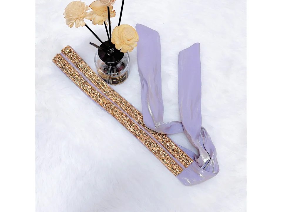 A close-up of the gold embellished belt accessory for the dress.