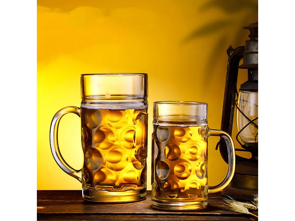 Two glass beer mugs of different sizes filled with beer.
