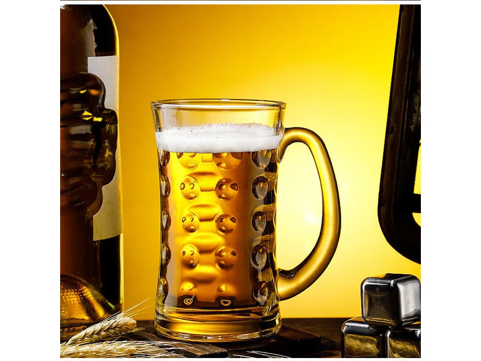 A glass beer mug filled with beer, sitting on a table.