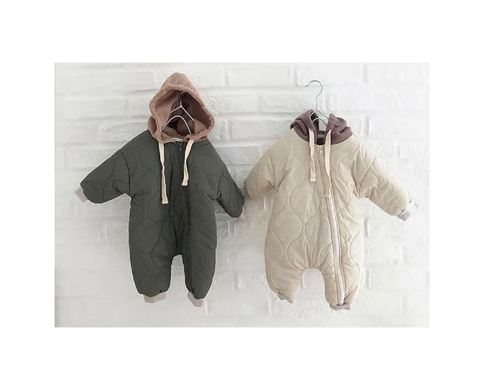 Two baby hooded jumpsuits, one olive green and one beige, hanging side by side.