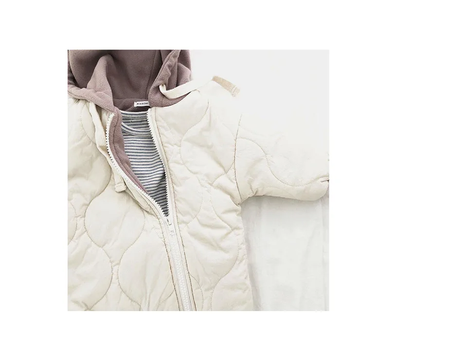 Close-up of the beige jumpsuit showing the zipper and soft inner lining.