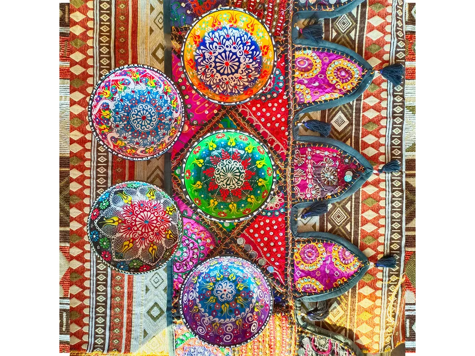 Five different Turkish style ceramic bowls arranged on a decorative textile background.