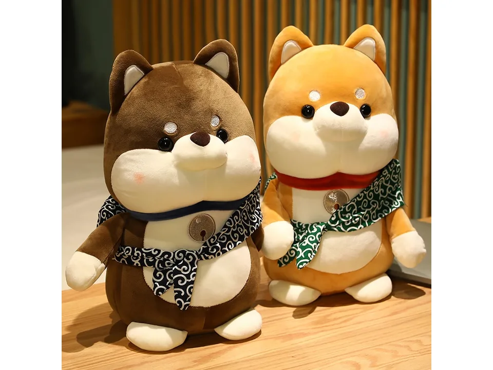 Two Shiba Inu plush toys, one brown and one tan, sitting on a wooden surface.