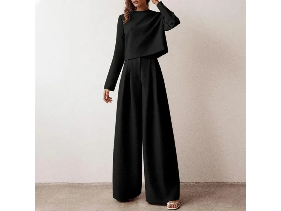 A woman wearing a black long-sleeve top and matching wide-leg pants.