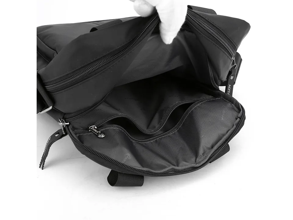 Interior view of the black messenger bag showing zippered compartments and lining.