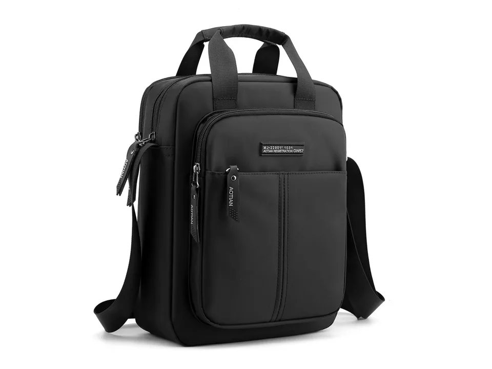 Black vertical messenger bag with shoulder strap and top handles.