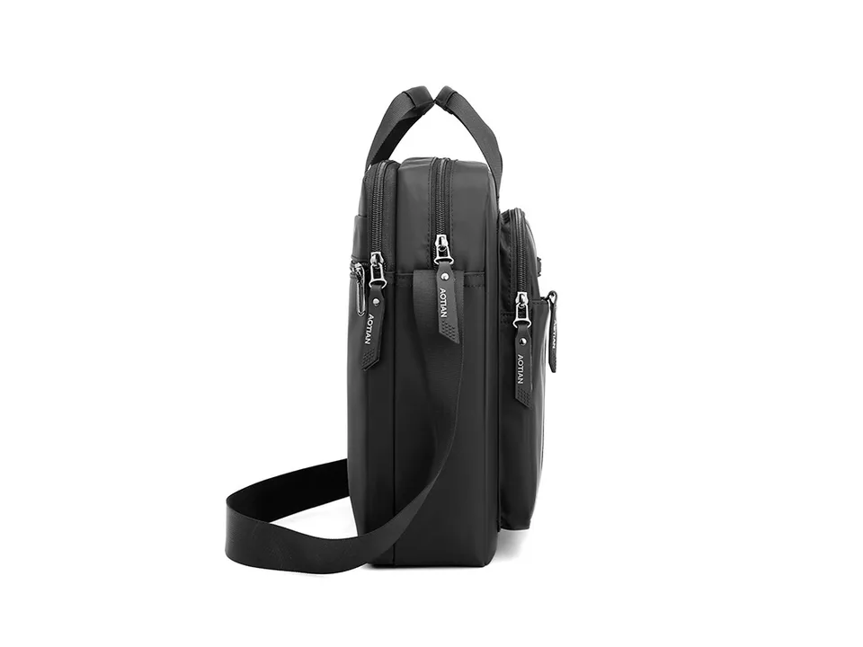 Side profile view of the black messenger bag showing the thickness and strap attachment.