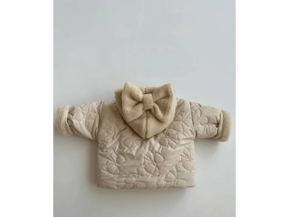 Back view of the beige quilted hooded jacket showing the large bow on the hood.