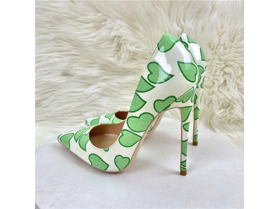 Side view of the white and green heart-patterned stiletto pumps.