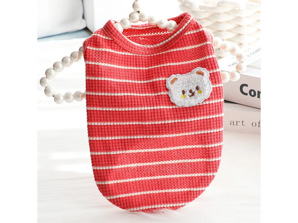 Red and white striped dog vest with a bear patch on a hanger.