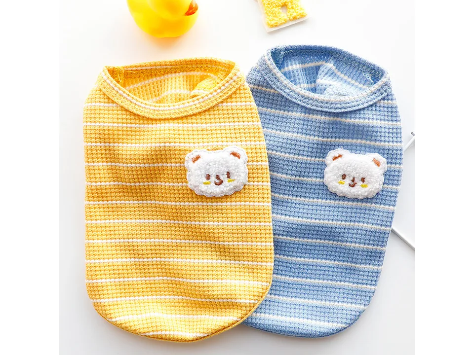 Yellow and blue striped dog vests with bear patches side by side.