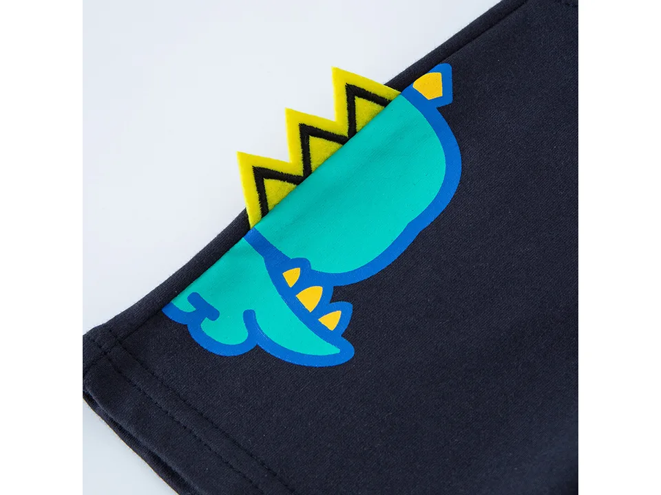 Close-up of the dinosaur graphic and yellow spikes on the side of the shorts.