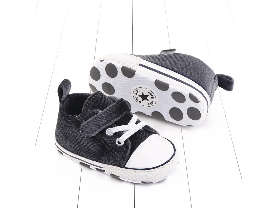 A pair of grey toddler sneakers shown from the side and bottom.