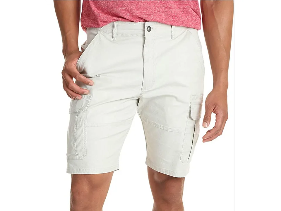 A man wearing light beige cargo shorts with side pockets.