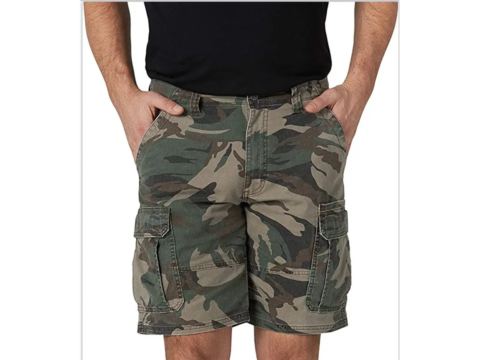 A man wearing camouflage cargo shorts with side pockets.