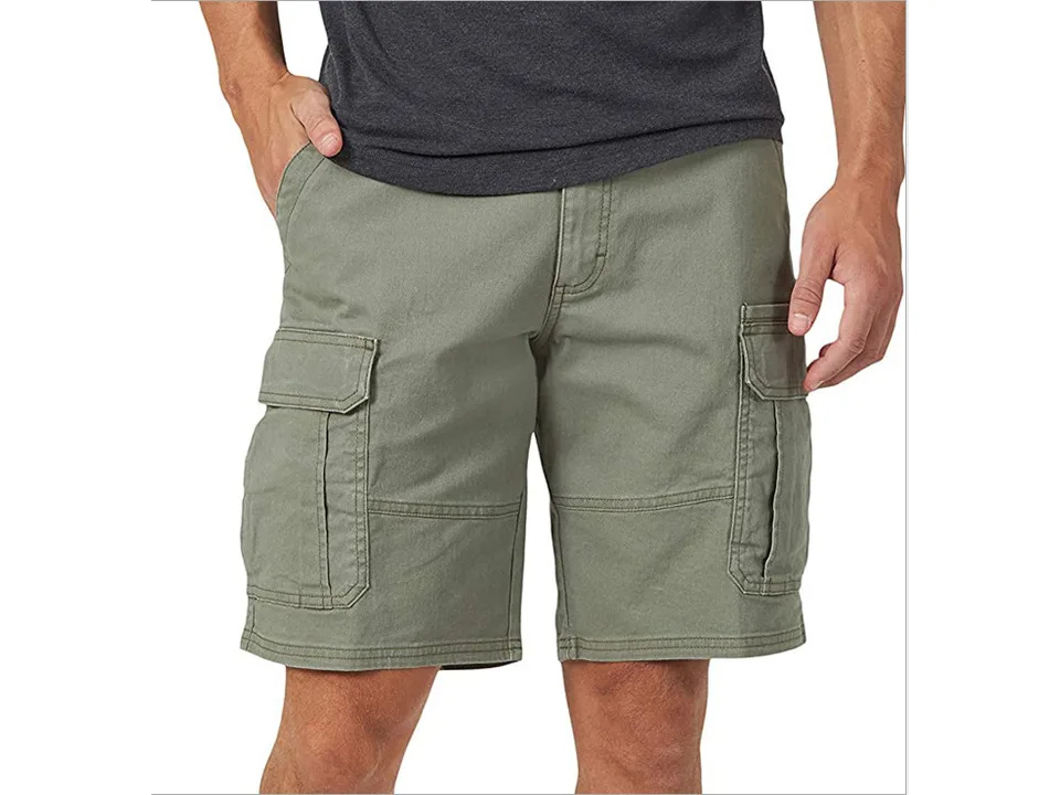 A man wearing olive green cargo shorts with side pockets.