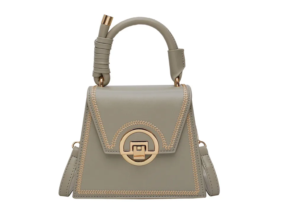 A light green small square handbag with gold embroidery and a gold lock closure on a white background.