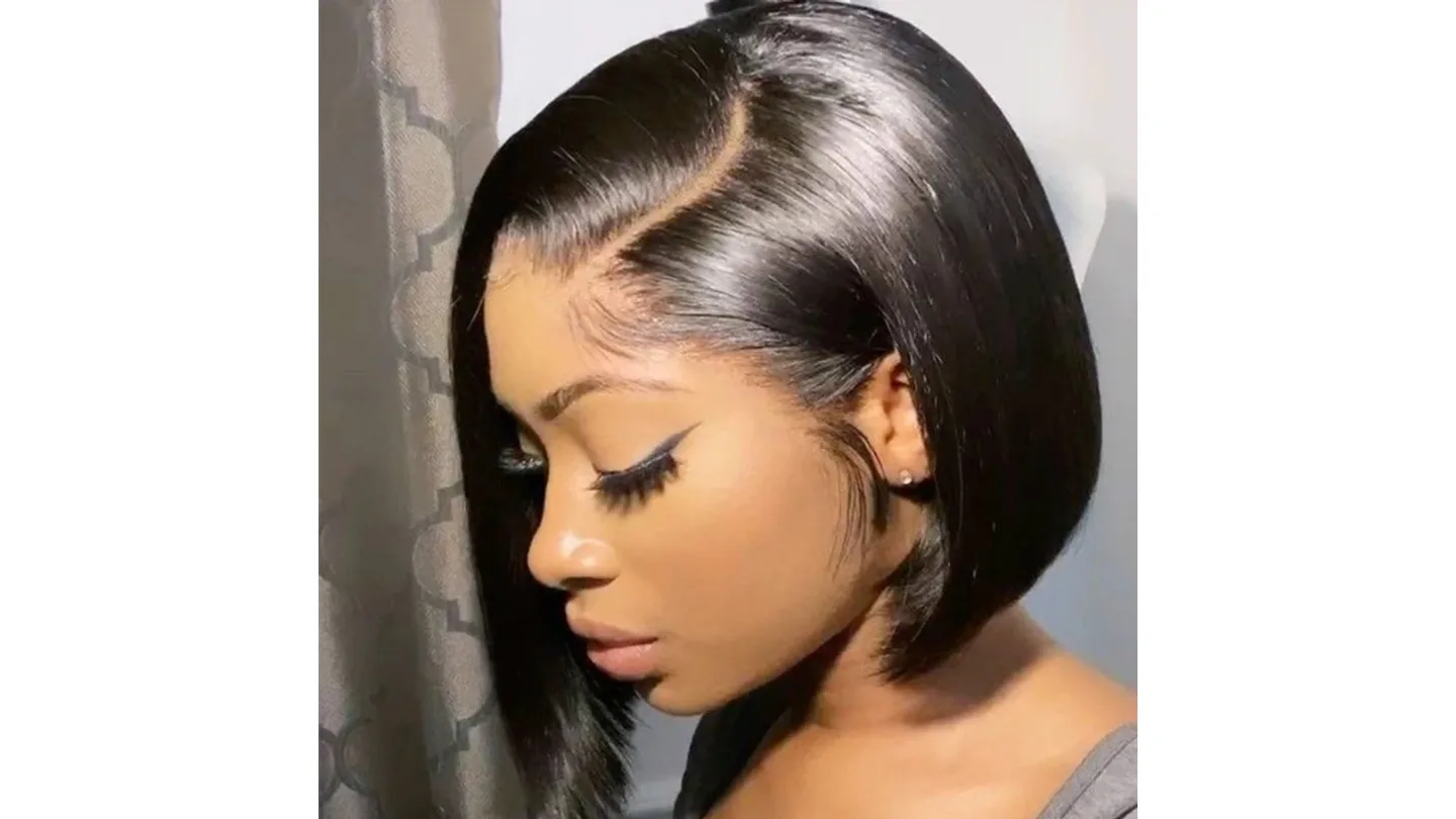 A woman wearing a short black bob wig with a side part.