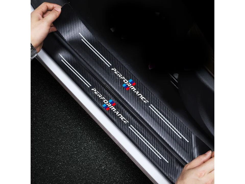 Hands applying a carbon fiber style door sill protector sticker to a car frame.