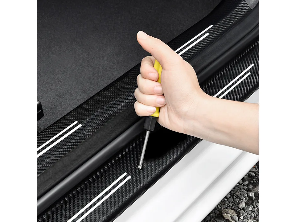 Close-up of a screwdriver pressing down on the installed door sill protector.