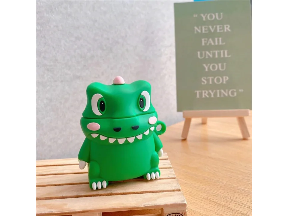 A green dinosaur-shaped silicone earphone case standing on a small wooden pallet.