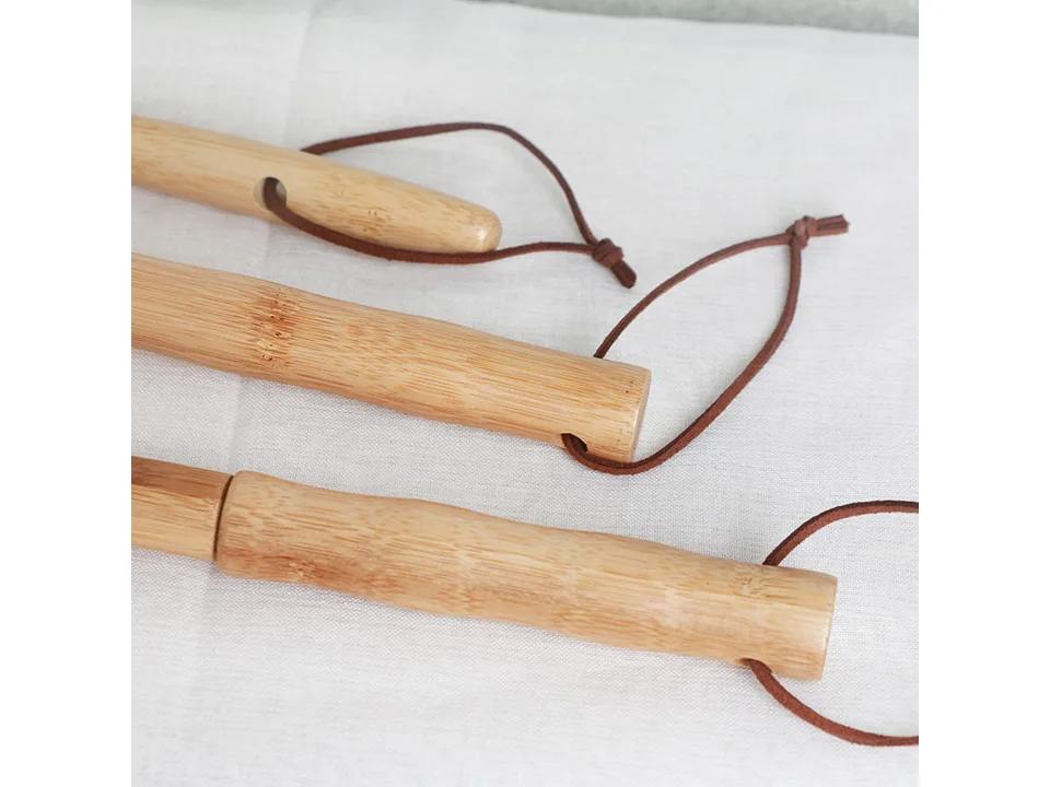 Close-up of the wooden handles and leather hanging loops of the dusters.