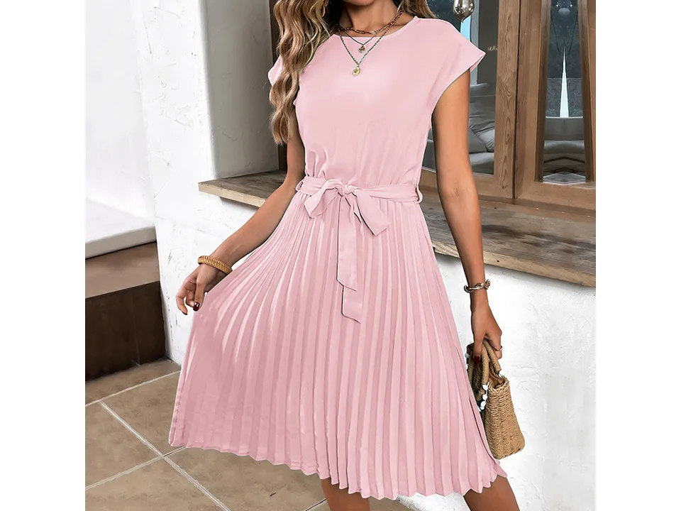 A woman wearing a pink pleated midi dress with a tie waist.