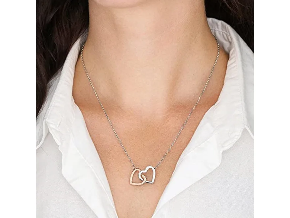 A woman wearing the interlocking double heart necklace with a white shirt.