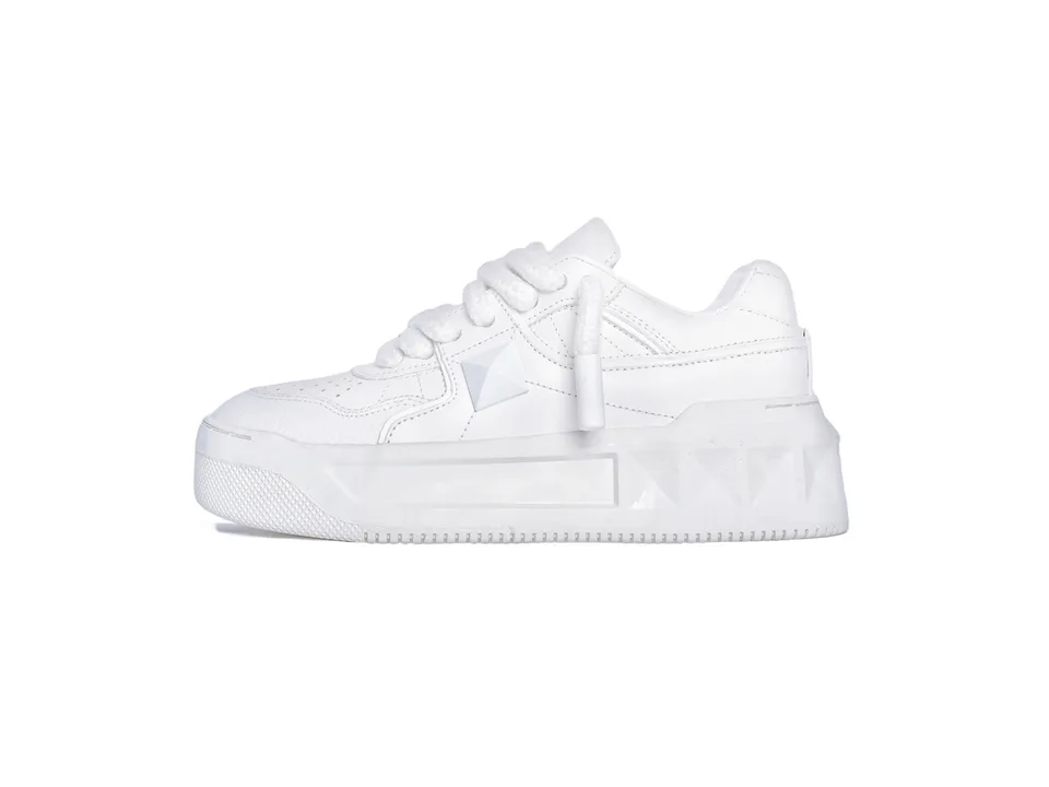 Side view of a white platform sneaker with a rivet detail.