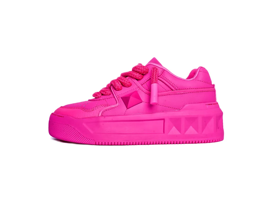Side view of a bright pink platform sneaker with a rivet detail.