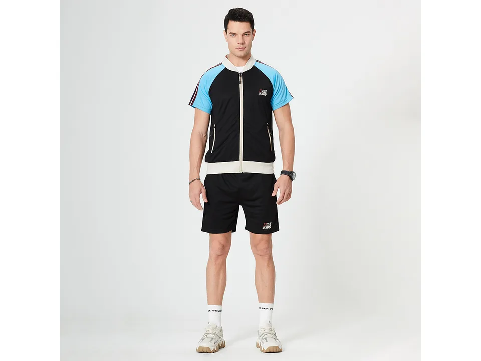 A man wearing a black and blue athletic short sleeve top and matching shorts.