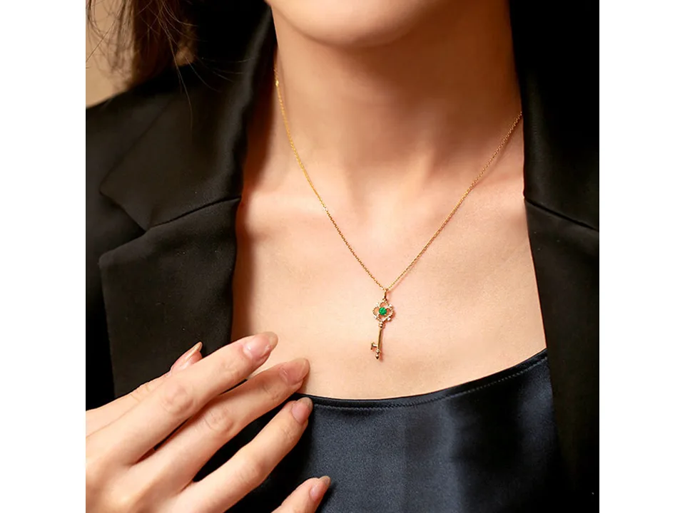 A person wearing the gold key pendant necklace.