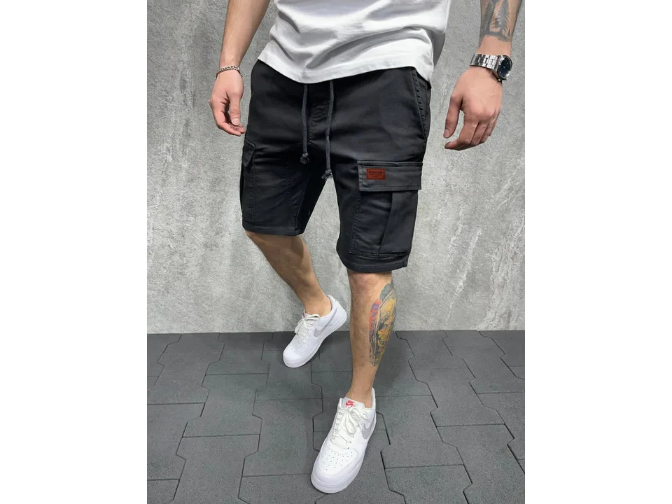 Man wearing black cargo shorts with side pockets and a drawstring waist.