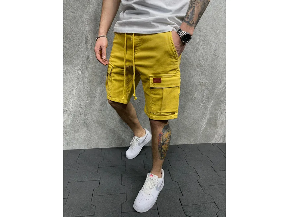 Man wearing yellow cargo shorts with side pockets and a drawstring waist.