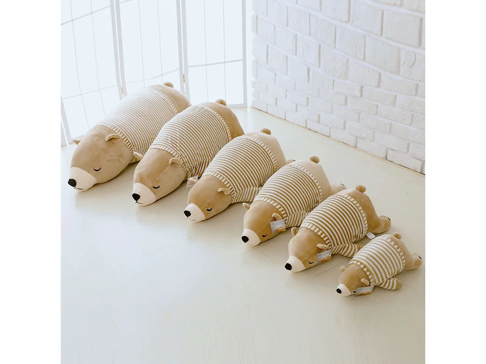 A row of six polar bear plush toys in different sizes, lined up from largest to smallest.