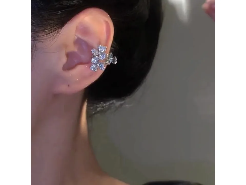 Close-up of the flower ear cuff worn on the ear.