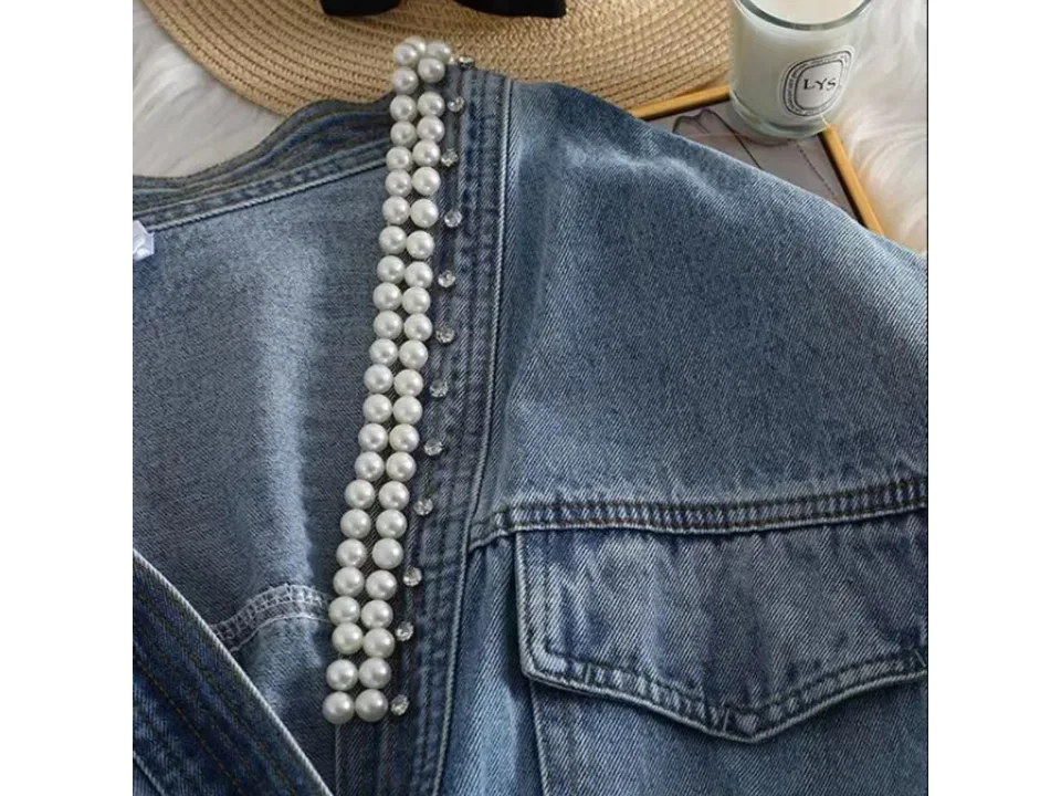 Close-up of the pearl and rhinestone embellishments on the denim jacket.