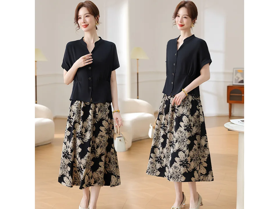 A model wearing a black short-sleeve shirt and a floral print skirt.
