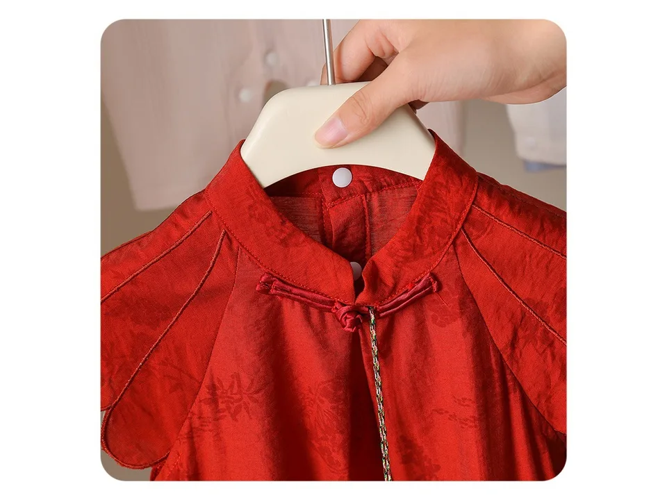 Close-up of the red romper collar with traditional knot button closure.