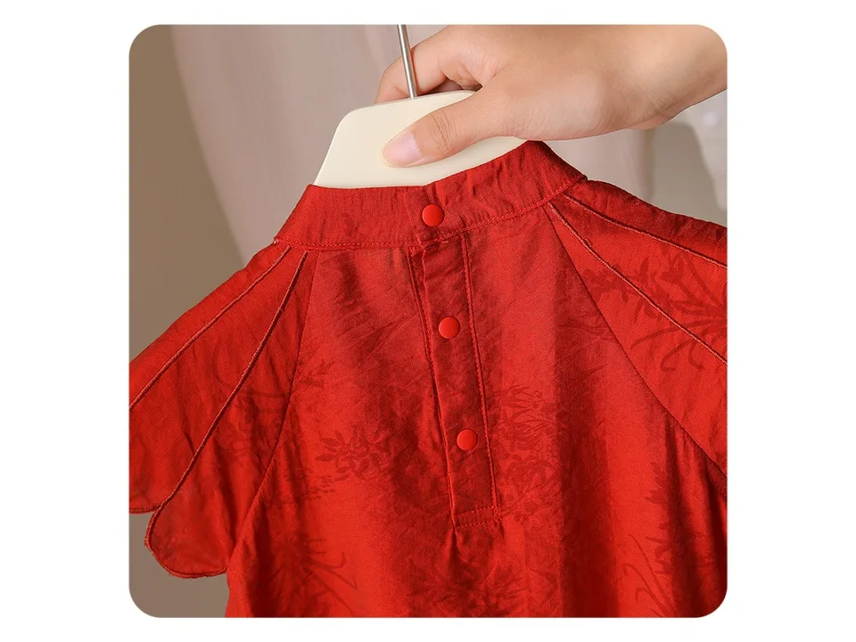 Close-up of the back of the red romper showing the button closure.