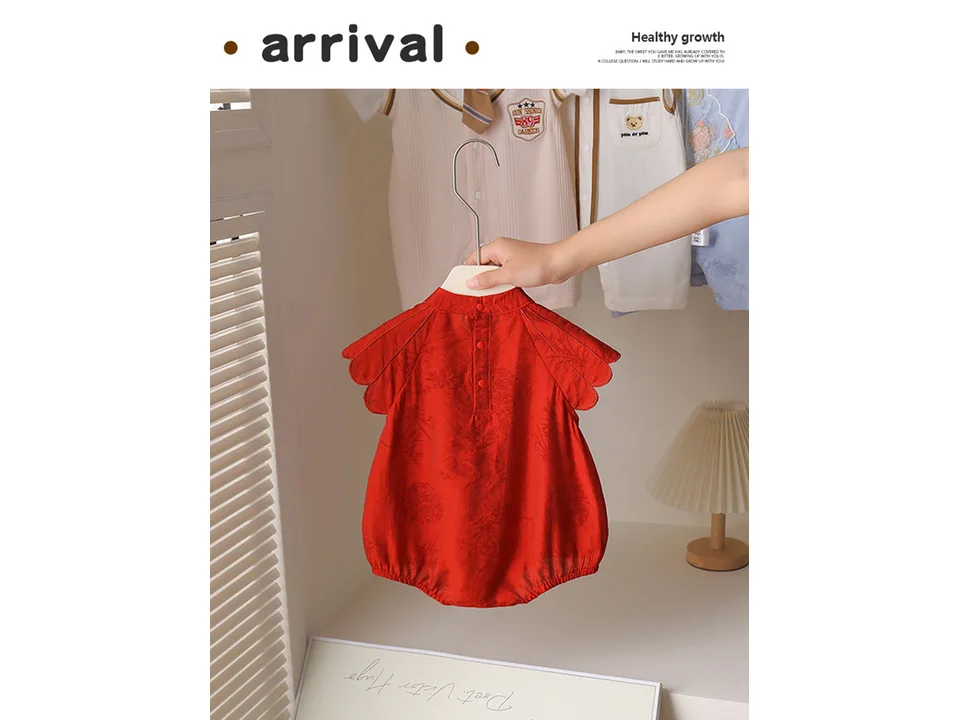 A red traditional Chinese style baby romper on a hanger.