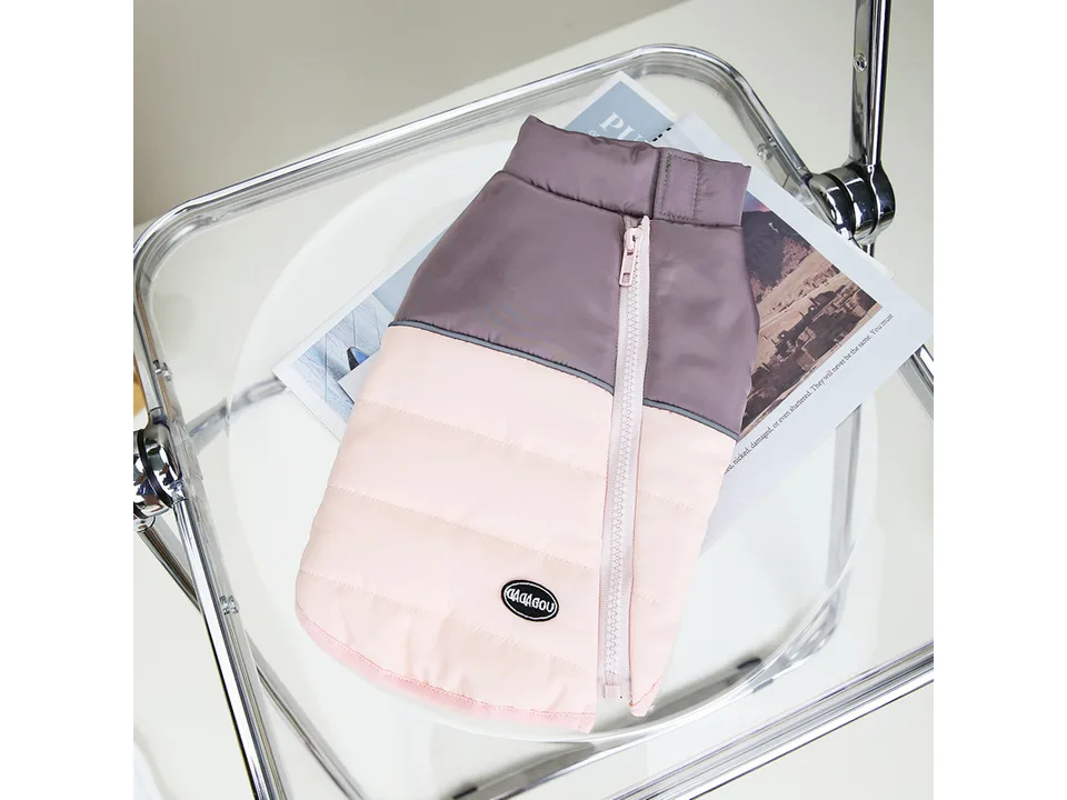 A pink and grey quilted dog vest with a zipper closure.