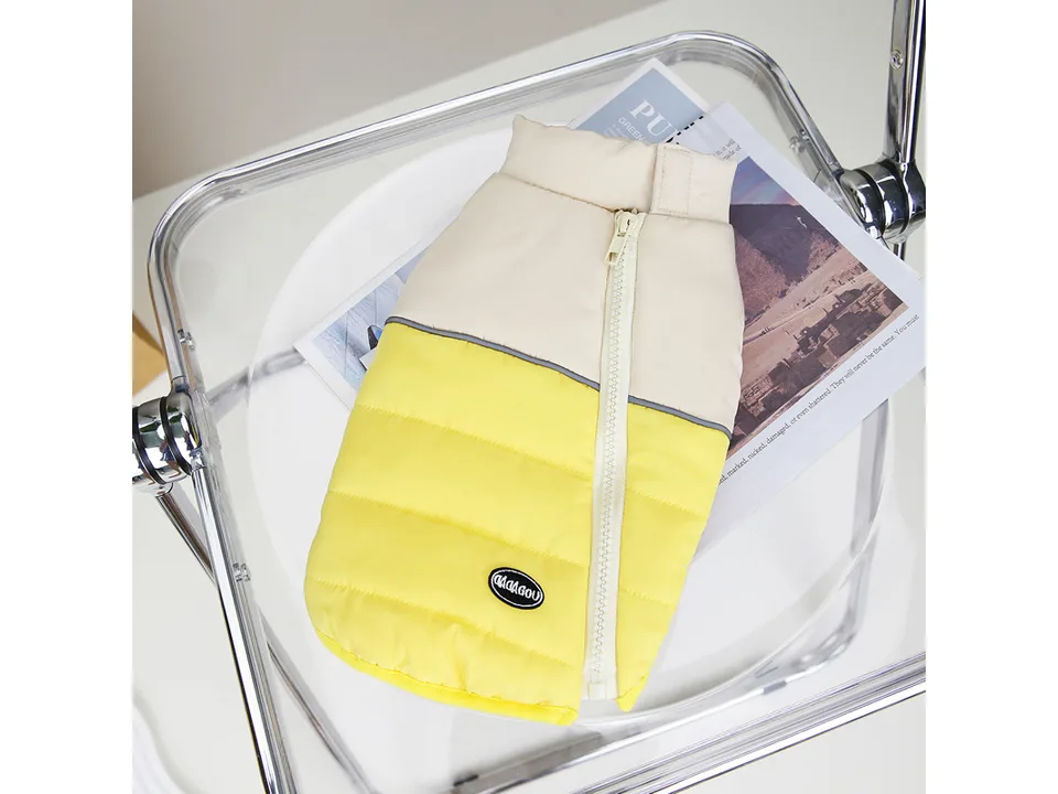 A yellow and beige quilted dog vest with a zipper closure.