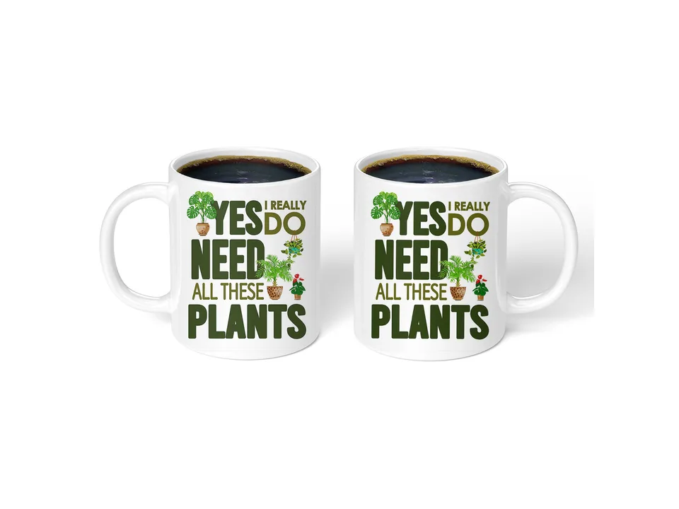 Two white ceramic mugs side-by-side, both featuring a plant-themed design and text.