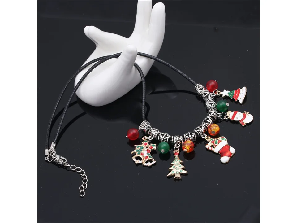 Christmas charm necklace on a white hand-shaped display stand.