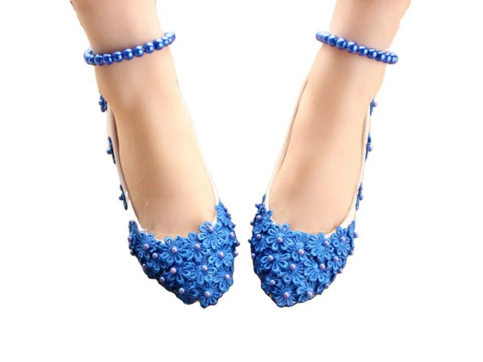 Front view of blue floral lace high heels with pearl accents worn on feet.