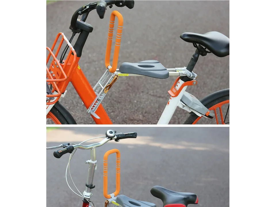 Close-up of the orange child seat handle and grey seat mounted on a bicycle frame.