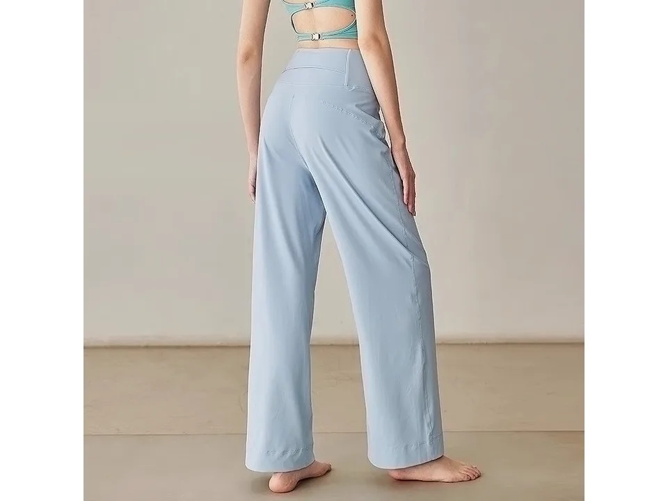 A model wearing light blue loose-fitting yoga pants, viewed from the back.