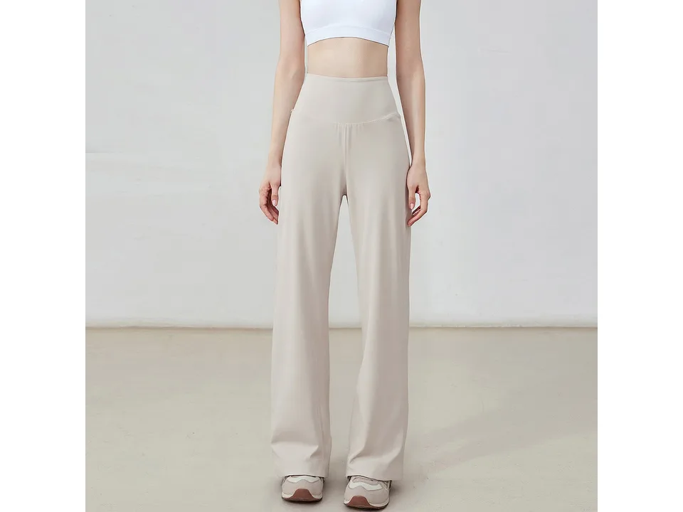 A model wearing beige loose-fitting straight-leg yoga pants.