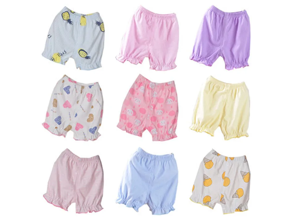A collection of nine different baby bloomer shorts with various patterns and colors.